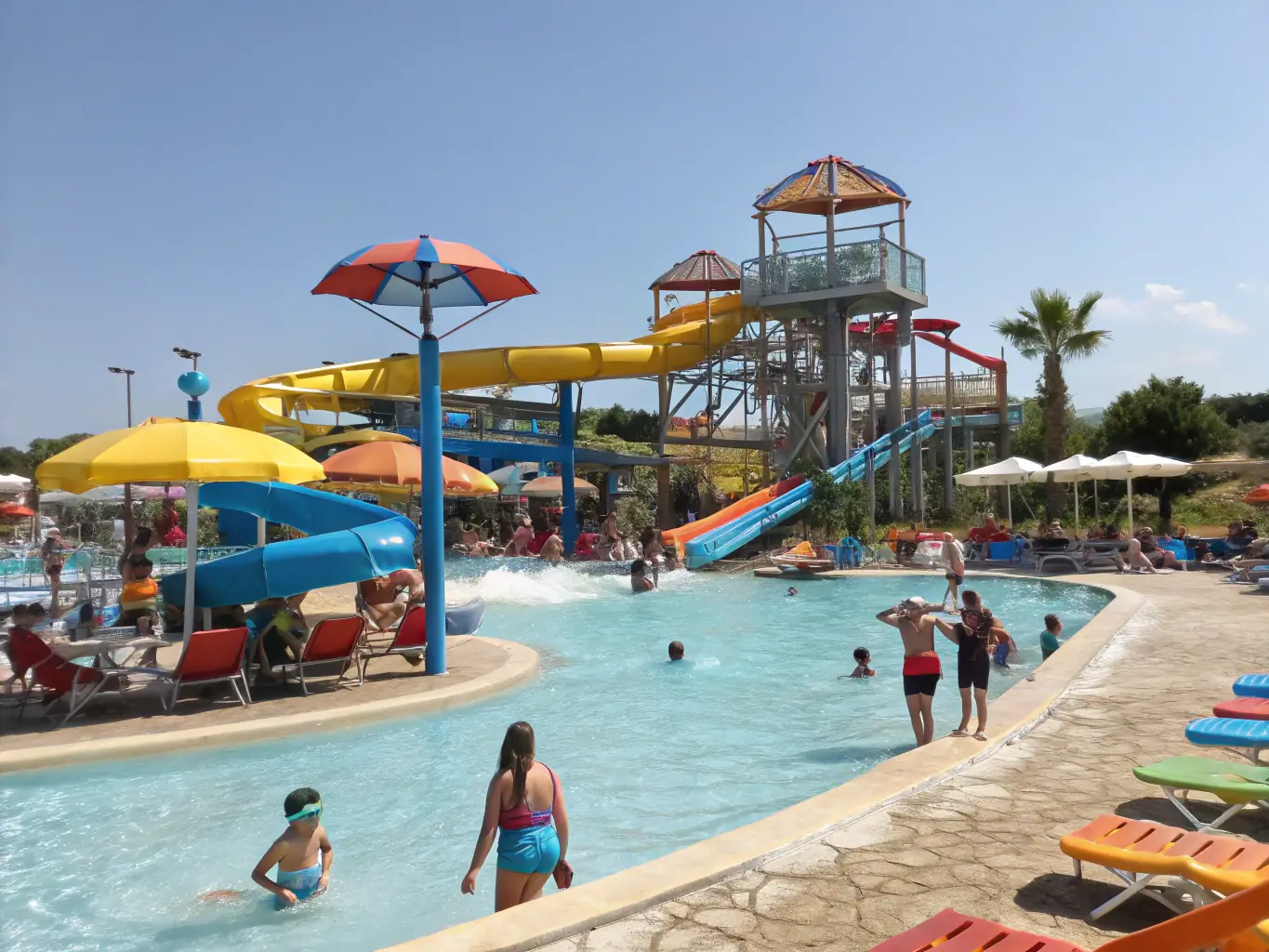 A wide shot of Energylandia's water park, showcasing various slides, pools, and water attractions with people enjoying themselves under the sun.